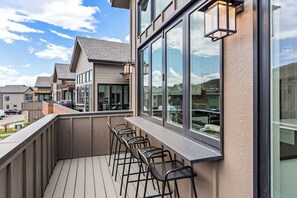 Ein Balkon mit Sitzgelegenheit und großen Fenstern.