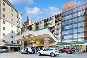 A Sheraton hotel with a prominent entrance, multiple floors, and a flag. - Ski-in/ski-out condo in Sheraton with pool, hot tub, mountain view & fireplace (Steamboat Springs)