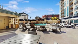 Área de piscina no terraço com espreguiçadeiras e piscina.