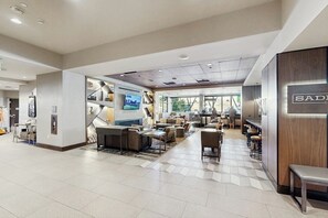 A spacious lobby with seating areas, a reception desk, and a large window providing a view of the outdoors. - Ski-in/ski-out condo in Sheraton with pool, hot tub, mountain view & fireplace (Steamboat Springs)