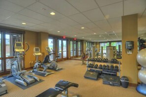 A gym with treadmills, elliptical machines, dumbbells, and benches. - Renovated, ground-floor condo with pool, hot tubs & gym - steps to gondola (Steamboat Springs)