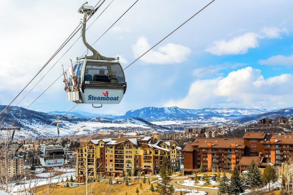 Un téléphérique de Steamboat offrant une vue sur une ville de montagne et un paysage enneigé.