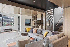 Ein modernes Wohnzimmer mit einem Ecksofa, einem runden Couchtisch und integrierten Regalen.