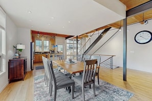 Eine moderne Küche mit Essbereich, Holzboden und einer Treppe.