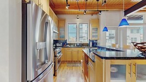 Una cocina moderna con electrodomésticos de acero inoxidable, armarios de madera y una isla grande.