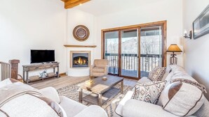 A living room with a fireplace, a television, and a sofa. - River-view condo with fireplace & hot tub - walk to gondola & Main St (Telluride)