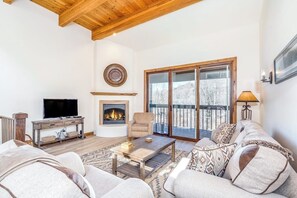Ein Wohnzimmer mit Kamin, Fernseher und Sofa.