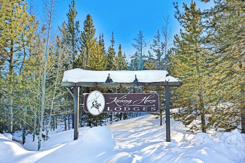 Lumipeitteinen alue, jossa on kyltti, jossa lukee ”Kicking Horse Lodges”, ja hevosen muotoinen logo.