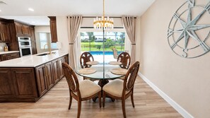 A kitchen with dark wood cabinets, a glass island, and a view of a swimming pool. - 3-bedroom pool home, near gulf coast beaches (Rotonda West)