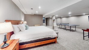 Una camera da letto con un letto, un comodino, una lampada e un tavolo da ping pong.