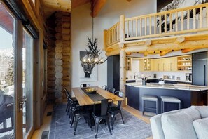 Ein rustikales Blockhaus im Inneren mit Essbereich, Küche und einem Balkon.
