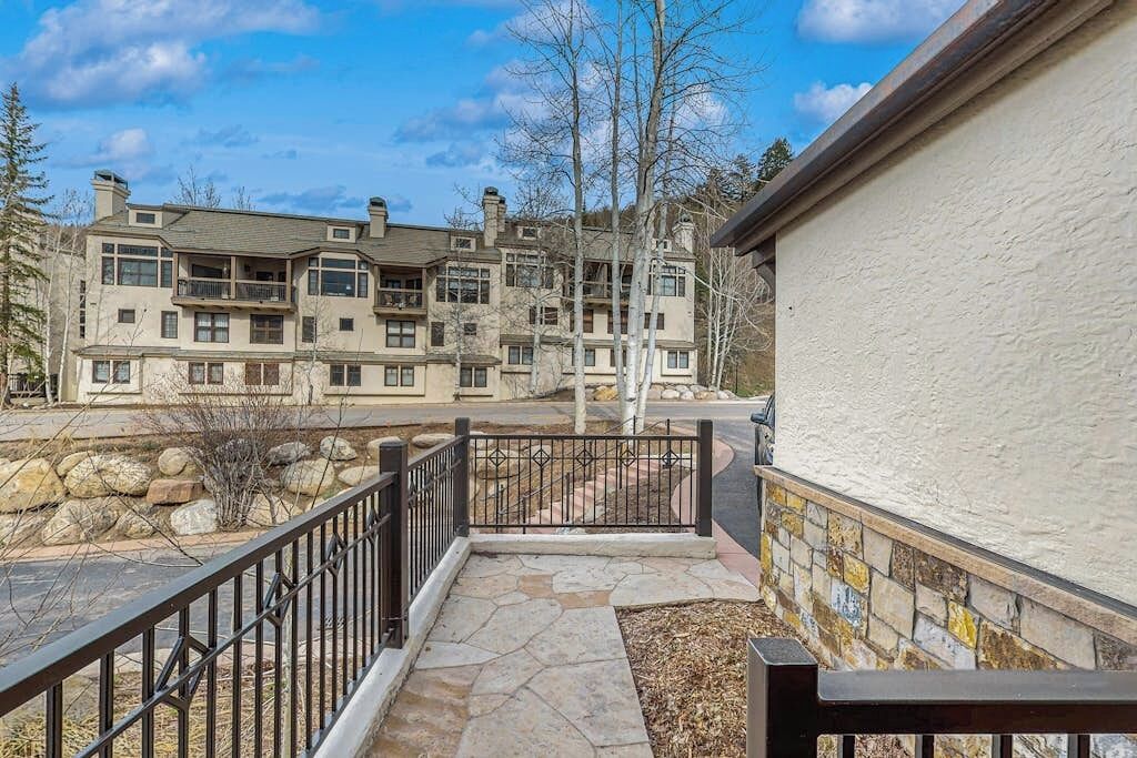A multi-story building with a stone pathway leading to a gated entrance.