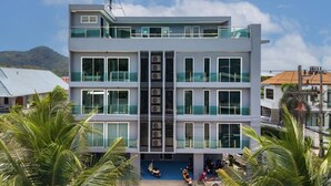 Un immeuble à plusieurs étages doté d’un atrium central, de balcons et d’un espace de stationnement pour scooters.