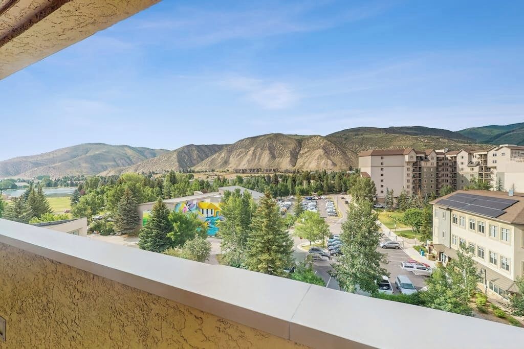 A residential area with apartment buildings, a parking lot, and a swimming pool.