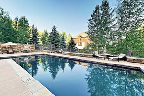 Ein Swimmingpool mit Liegestühlen und einer Steinterrasse.