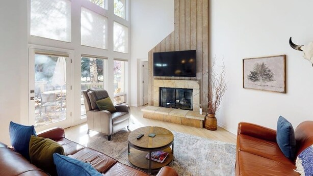 A spacious living room with a fireplace, large windows, and a view of the outdoors. - Springs of Arrowhead Getaway w/ Deck, Pool, Hot Tub & Village Shuttle (Edwards)