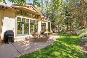 A house with a patio, outdoor seating, and a stone exterior. - Spacious Home w/Mountain Views, Game Room, Shared Hot Tub, Grill, & Pool Table (Edwards)