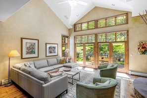 A spacious living room with a high ceiling, large windows, and a view of the outdoors. - Spacious Home w/Mountain Views, Game Room, Shared Hot Tub, Grill, & Pool Table (Edwards)