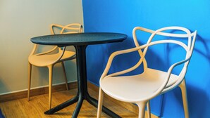 Two chairs and a table in a room with wooden flooring and a blue wall. - Villa Verona (Guatemala City)