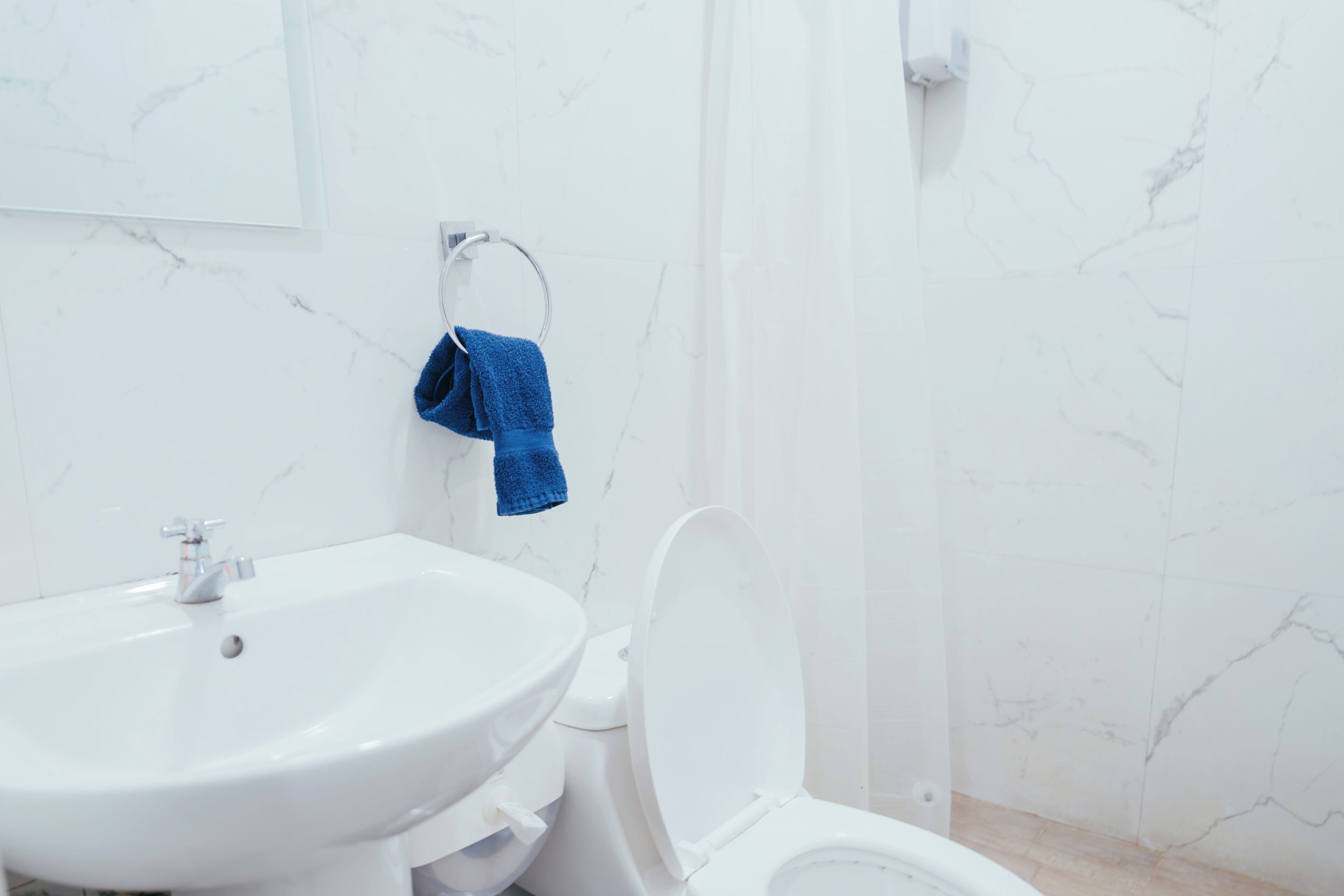 A bathroom with a white sink, toilet, and shower.