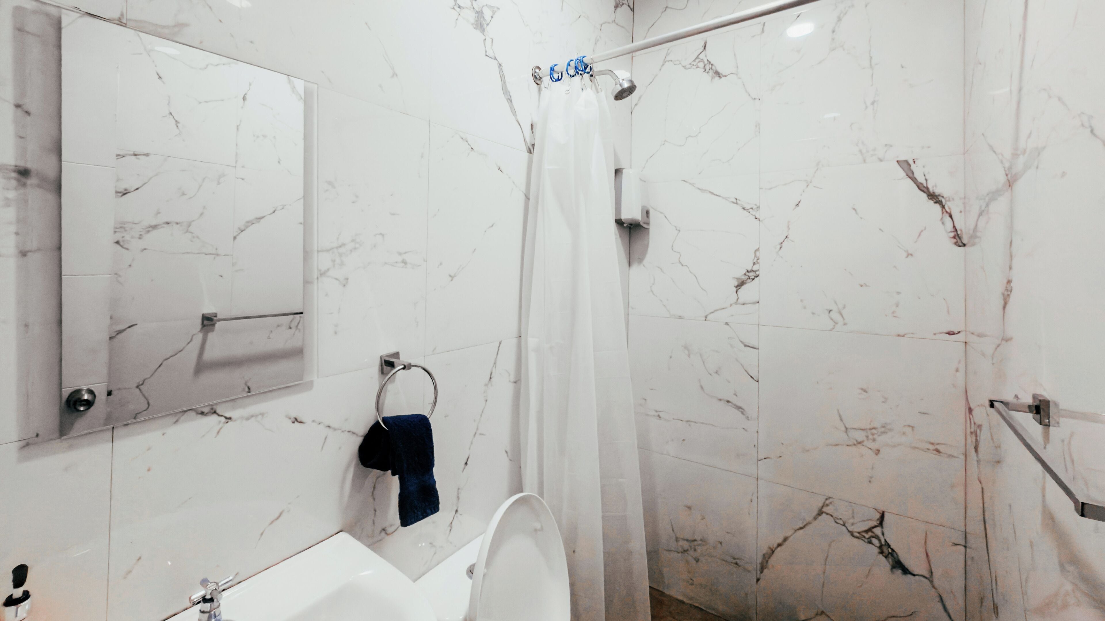 Une salle de bain équipée d’une douche, de toilettes, d’un lavabo et d’un miroir.