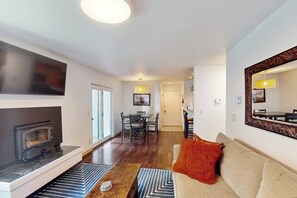 Ein modernes Wohnzimmer mit Kamin, Essbereich und einem großen Spiegel.