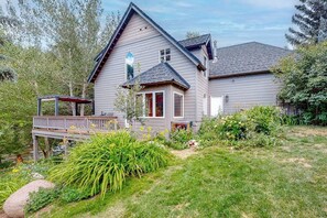 A two-story house with a deck, surrounded by a well-maintained garden. - Friendly Home with Gas Fireplace, High-Speed WiFi, & Central AC (Avon)