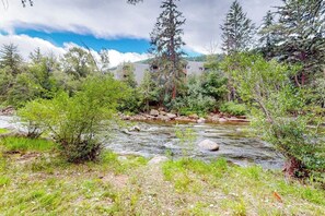 A river flowing through a natural landscape with trees and a building in the background. - Friendly Home with Gas Fireplace, High-Speed WiFi, & Central AC (Avon)