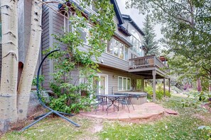 A two-story house with a covered patio, outdoor seating, and a garden area. - Friendly Home with Gas Fireplace, High-Speed WiFi, & Central AC (Avon)