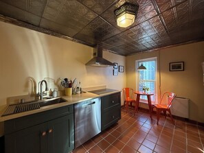 A kitchen with a stainless steel sink, a range hood, and a window with a view. - Railyard Rose: explore Santa Fe on foot from this central oasis (Santa Fe)