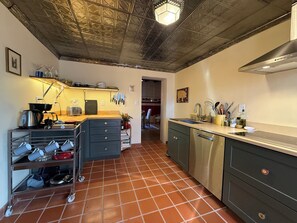 A kitchen with a tiled floor, a coffee machine, a sink, and a dishwasher. - Railyard Rose: explore Santa Fe on foot from this central oasis (Santa Fe)