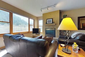 Ein Wohnzimmer mit Kamin, Fernseher und einer Couch.