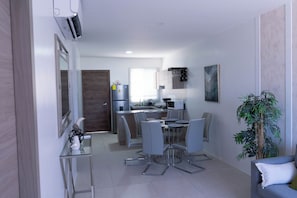 A modern kitchen with a dining area, a refrigerator, a microwave, and a sink.