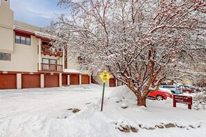 Un estacionamiento cubierto de nieve con un letrero que dice 'Mountain Inn Terrace Townhouses'.