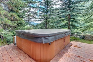 Ein Whirlpool auf einer Holterrasse, umgeben von Bäumen.