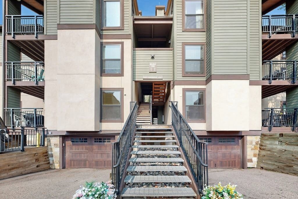 Un immeuble résidentiel à plusieurs étages, doté d’un escalier central, de balcons et d’un garage.