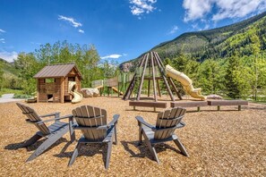 A playground with a slide, climbing structure, and a small cabin. - Secluded valley home w/ private balcony, grill, shared tennis - close to trails (East Vail)