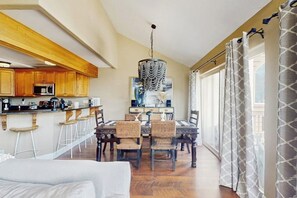 A dining area with a chandelier, wooden cabinets, and a view of the city through large windows. - Spacious mountain retreat minutes from Beavercreek w/shared pool/hot tub & patio (Edwards)