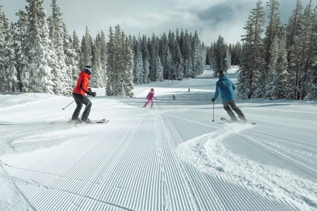 Ein verschneiter Skipisten mit Skifahrern.