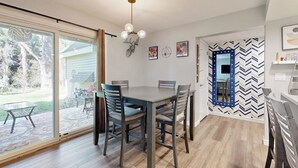 A dining area with a table and chairs, a ceiling light fixture, and a wall with a mirror and decorative items. - Mountain-view condo with outdoor pool, fireplace, patio, pool table & W/D (Edwards)