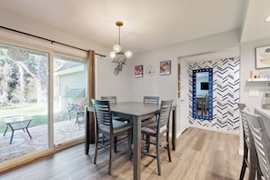 A dining area with a table and chairs, a ceiling light fixture, and a wall with a mirror and decorative items. - Mountain-view condo with outdoor pool, fireplace, patio, pool table & W/D (Edwards)