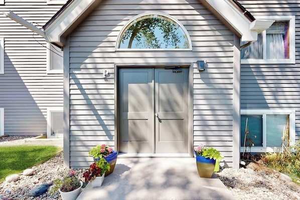 A house with a double door, a small window, and two flower pots. - Mountain-view condo with outdoor pool, fireplace, patio, pool table & W/D (Edwards)