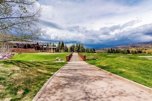 Ein Golfplatz mit einem Betonweg, der zu einem Clubhaus führt.