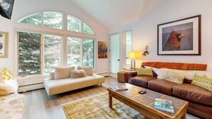 A modern living room with a sofa, a coffee table, and a fireplace. - All-season condo near ski lifts & golf course, with pool, & hot tub (Edwards)