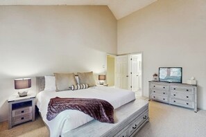 A bedroom with a bed, nightstands, a dresser, and a television. - Conveniently located condo w/ full kitchen & fast wifi - near skiing and golf (Avon)