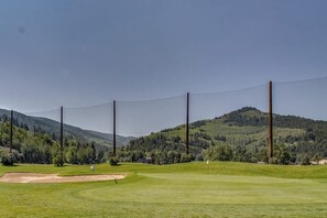 A golf course with a clear sky, a flagstick, and a distant mountain. - Conveniently located condo w/ full kitchen & fast wifi - near skiing and golf (Avon)