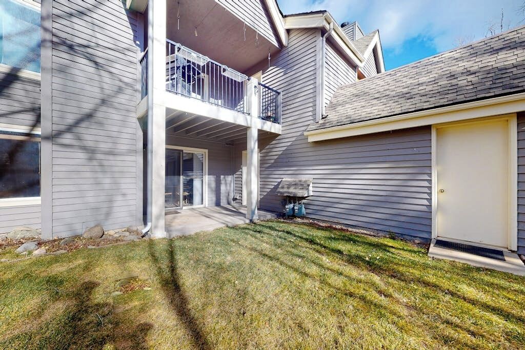 Ein zweistöckiges Wohnhaus mit überdachter Terrasse, Garage und gepflegtem Rasen.