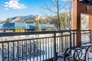 A balcony with a view of a ski resort, including a ski lift and mountains in the background. - Ski-in/out home with fireplace, AC, high-speed WiFi, shared pool/hot tub/laundry (Vail)