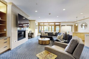 Ein modernes Wohnzimmer mit Kamin, Sofa, Couchtisch und einem an der Wand befestigten Flachbildfernseher.