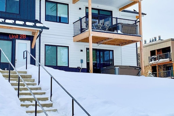 A multi-story building with a balcony, a staircase, and a sign indicating 'Unit 2B'. - Modern ground-floor studio with mountain view, kitchenette & parking (Fraser)